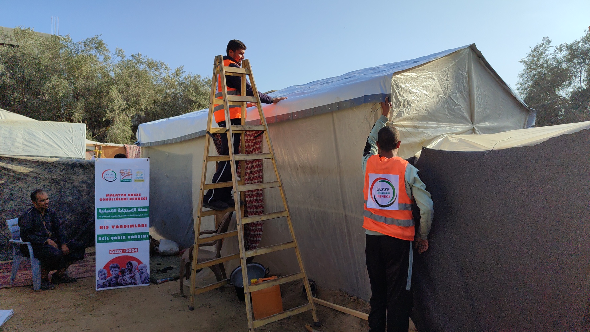 تغطية الخيام بالشوادر خلال المنخفض الجوي